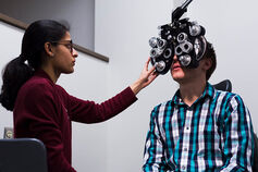An optometry student conducts an eye exam.